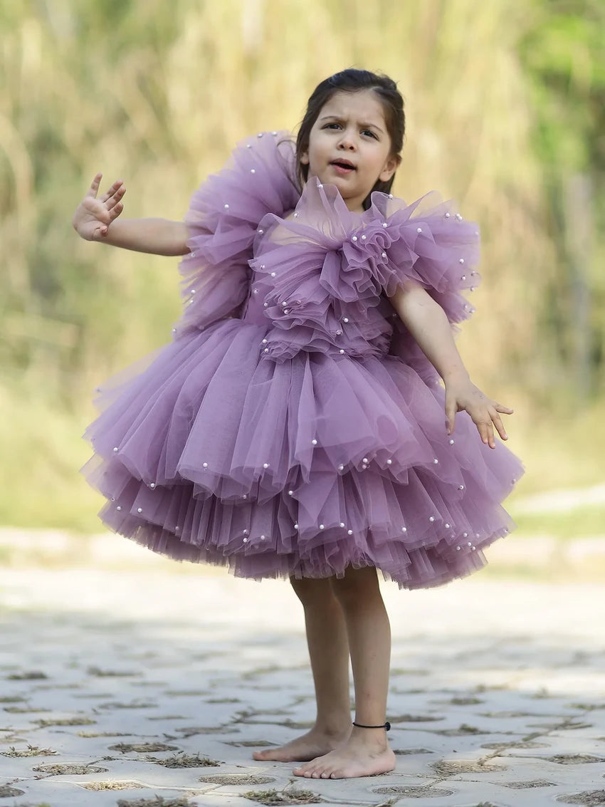 Side view of girls’ lavender princess gown with puffy tulle and pearl accents.