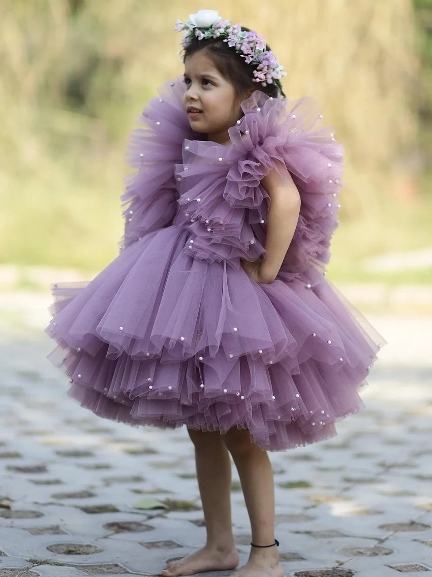 Side view of girls’ lavender princess gown with puffy tulle and pearl accents.