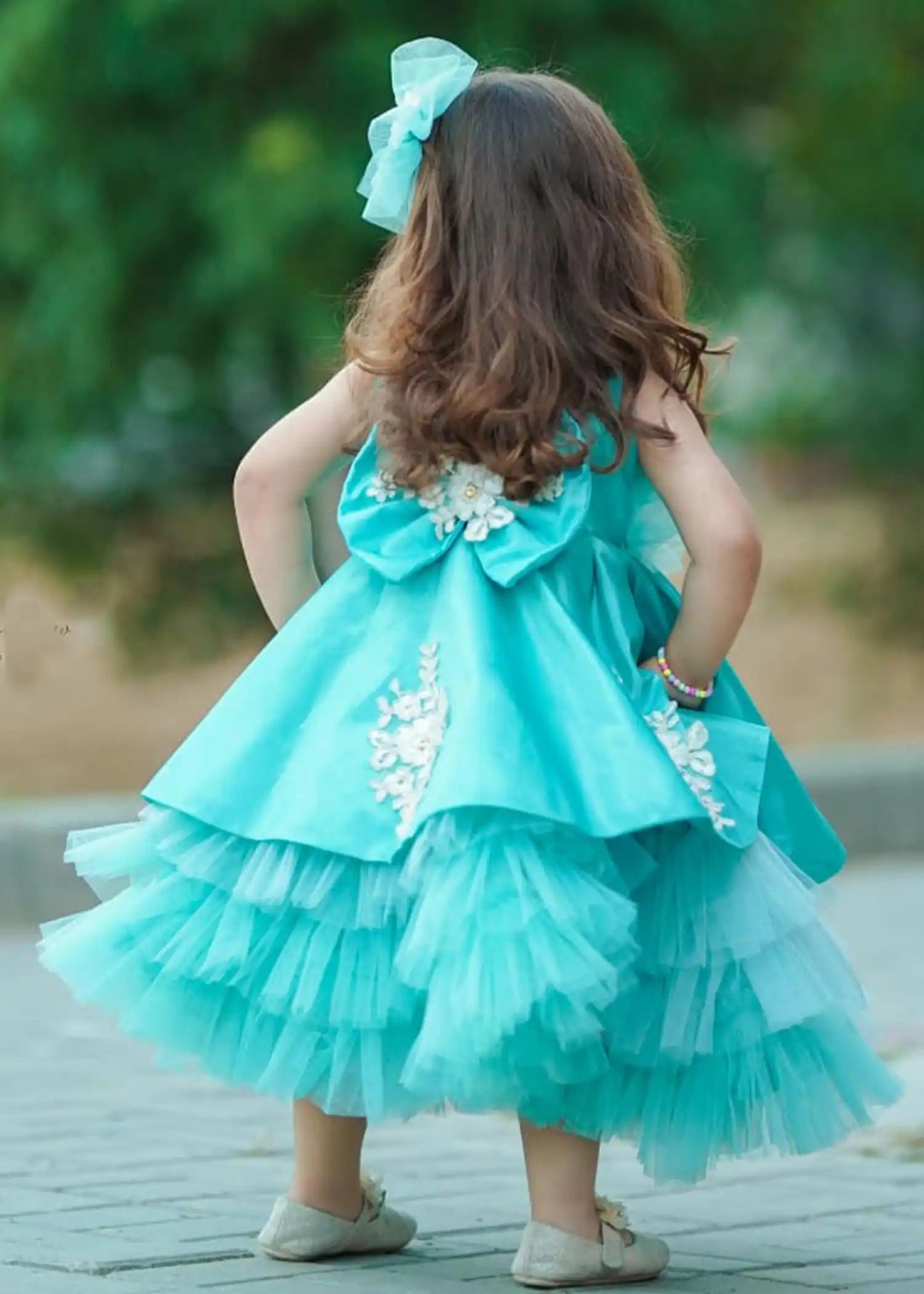 Little girl twirling in the Ariel Dress, capturing the enchanting spirit of birthdays and celebrations in a turquoise hue.