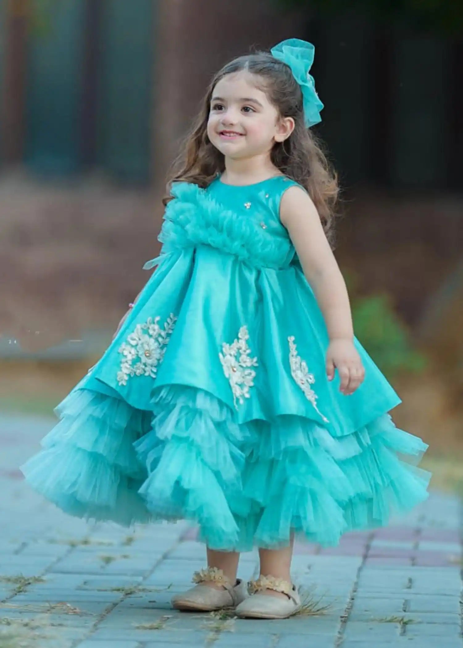 Ariel Dress showcasing layered tulle and floral accents in a captivating turquoise color, ideal for little princesses.