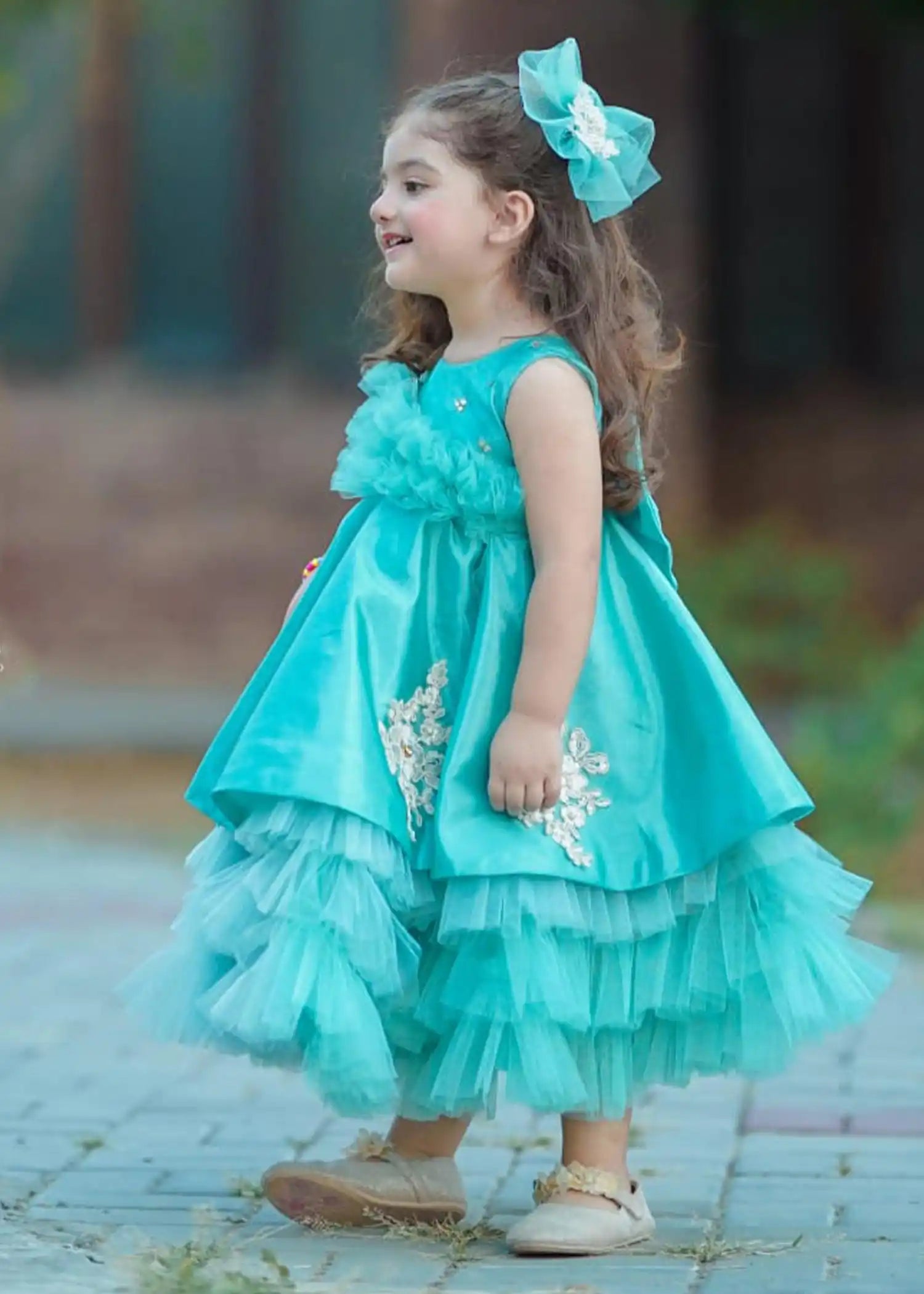 Ariel Dress displayed on a hanger, highlighting its magical turquoise design and luxurious craftsmanship for young dreamers.