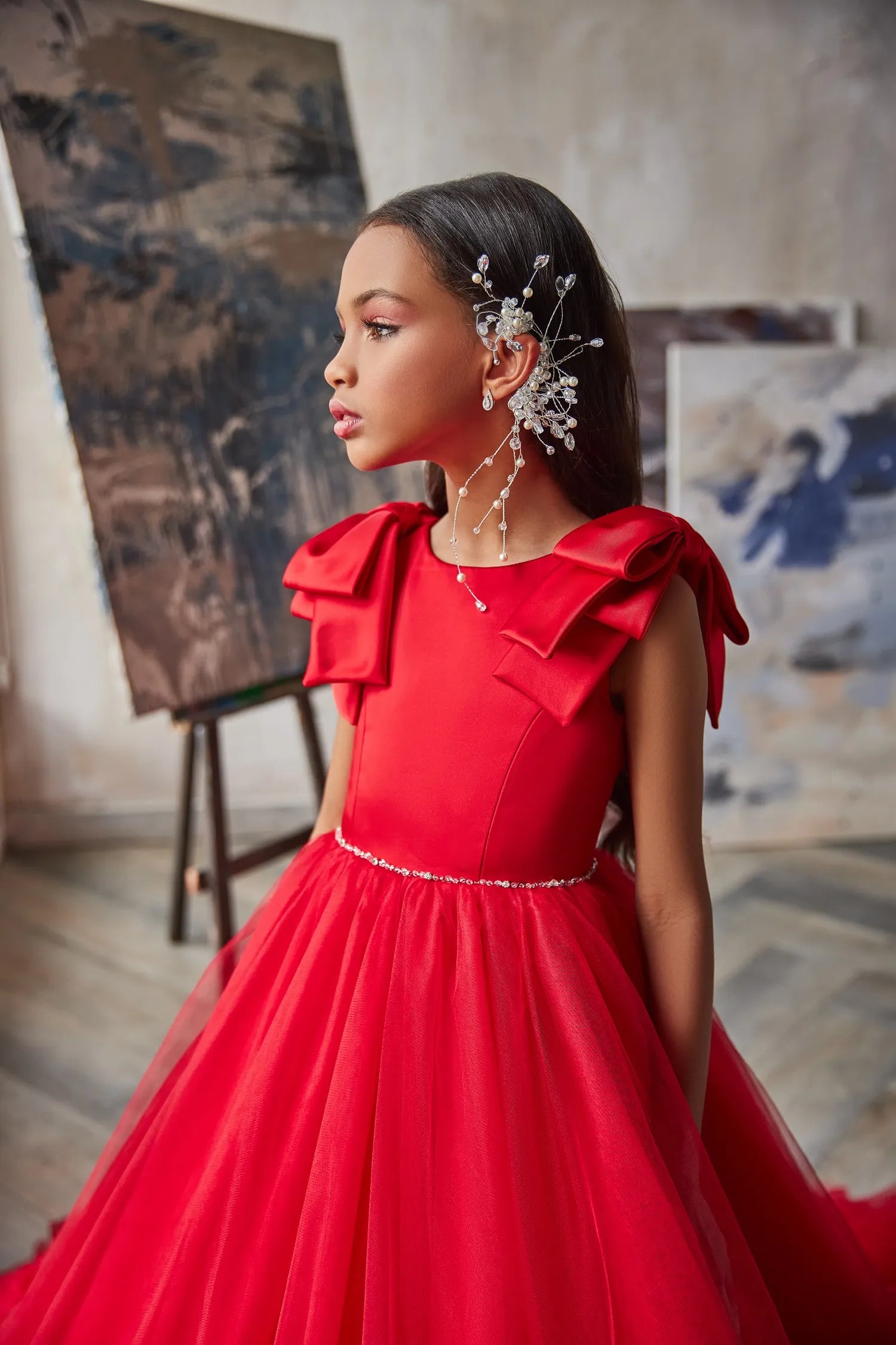 Close-up of Ruby Reverie red flower girl dress, featuring intricate tulle fabric and elegant ruffle details.