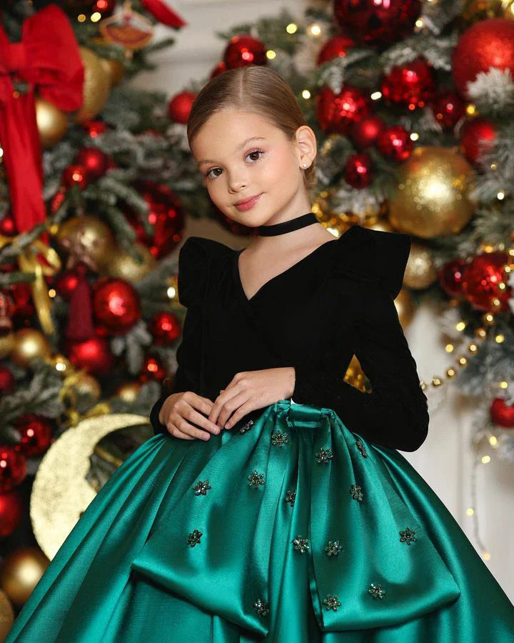 Close-up of pearl and satin accents on emerald green holiday dress for girls.
