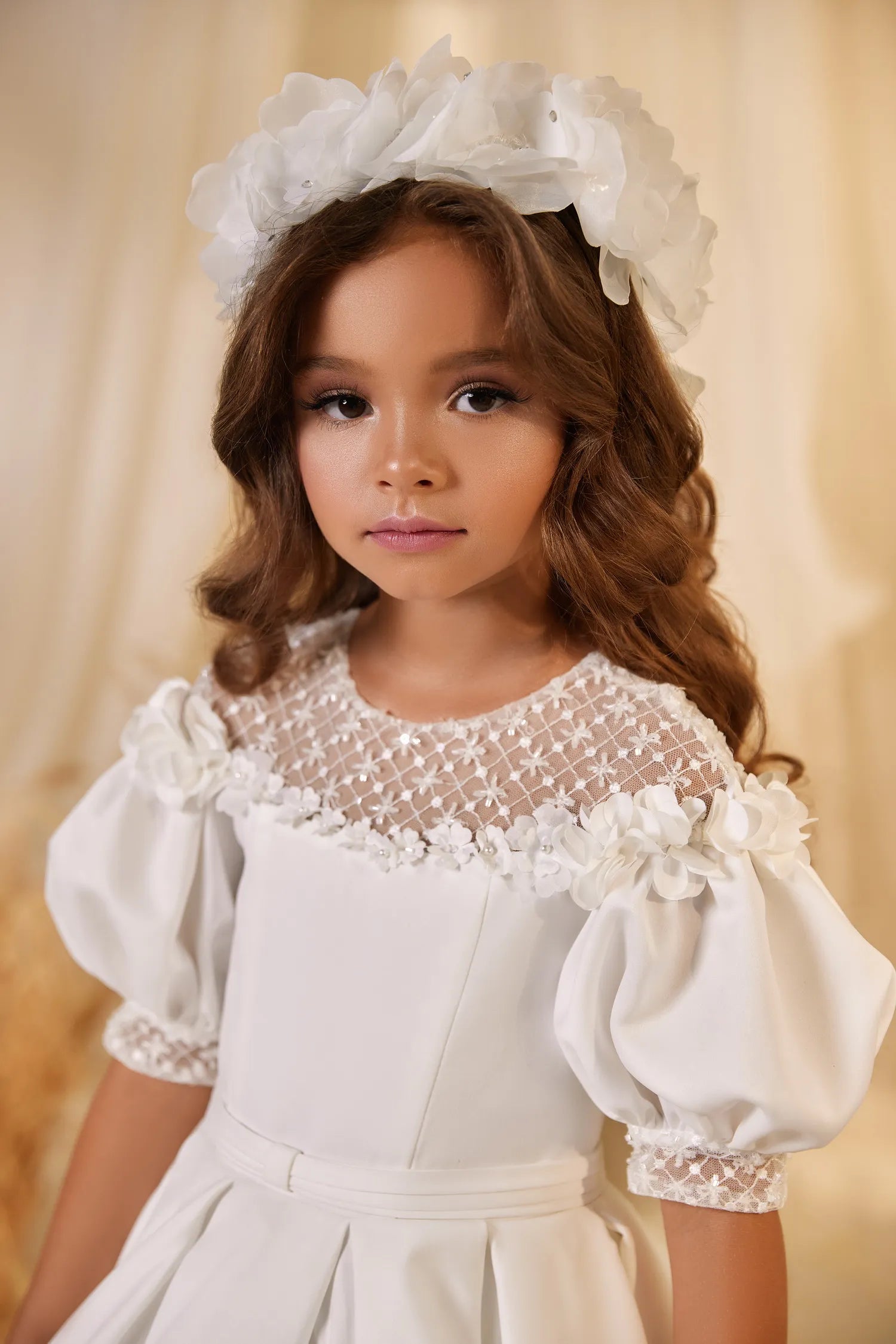 Close-up of puff sleeves and satin bodice detailing on flower girl gown.