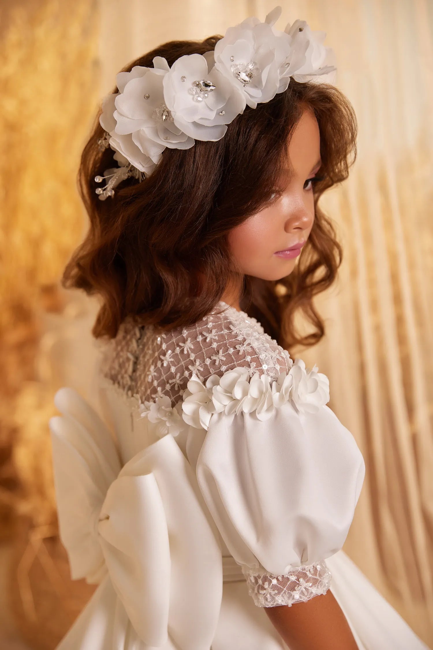 Side view of satin flower girl gown showing puff sleeves and elegant train.