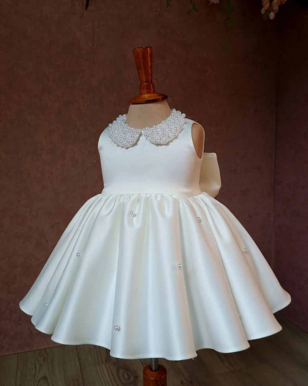 Side view of the white satin dress for girls, highlighting its soft fabric and classic A-line silhouette.