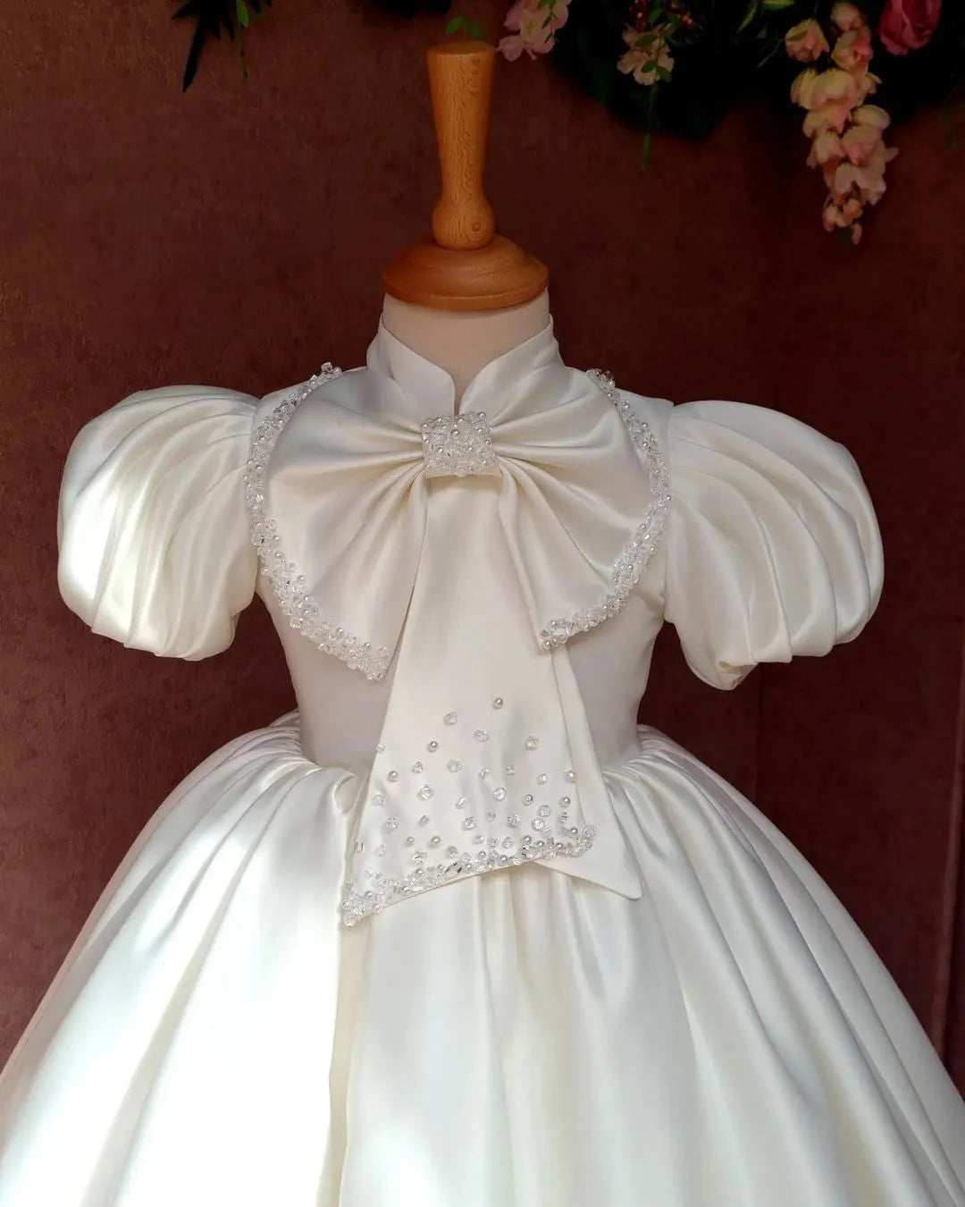 Front close view of the ivory satin dress, showcasing the drape and subtle sheen of the fabric.