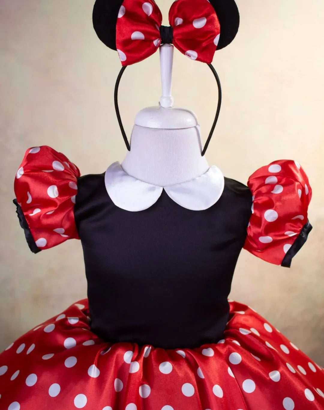 Close-up of Mickey Mouse accents and bow detail on a Disney-themed dress, showing intricate stitching and design.