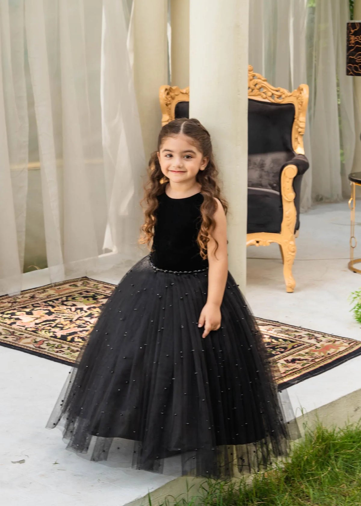 Front view of pearl-embellished black velvet gown for girls, elegant and luxurious