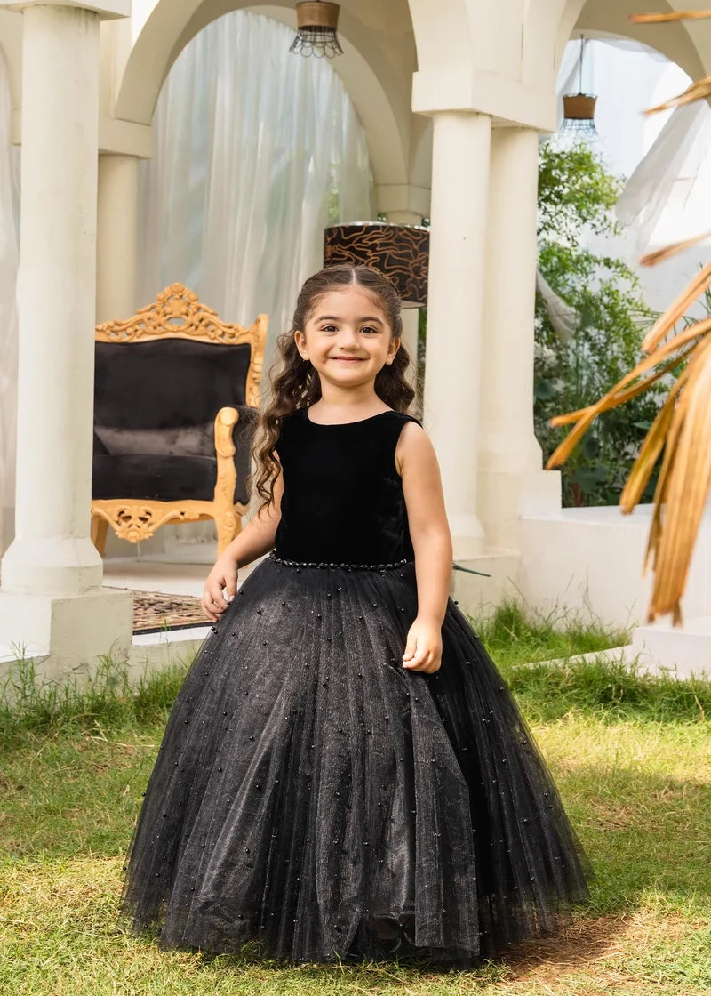 Side view of girls’ black velvet gown with pearls, showcasing timeless elegance