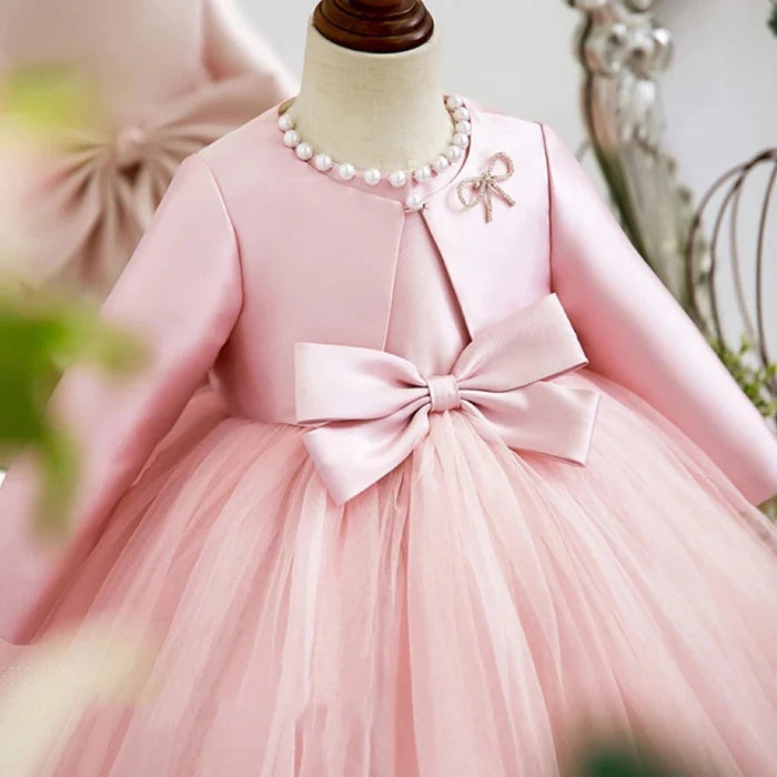 Close-up of double-bow front and delicate satin coat on princess birthday dress in pink.