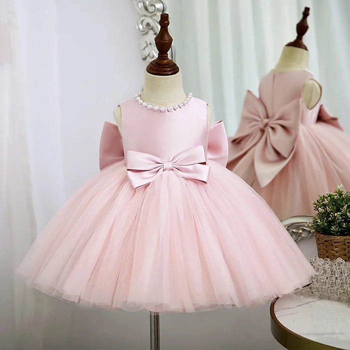 Side view of luxurious pink dress with puffy tutu and elegant bow detail for girls.