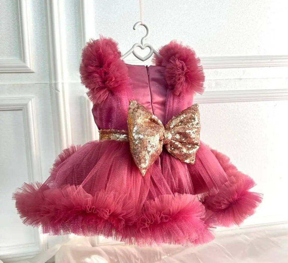 Back view of a dusty rose tutu dress with sparkling accents, showcasing flowing tulle and elegant details.