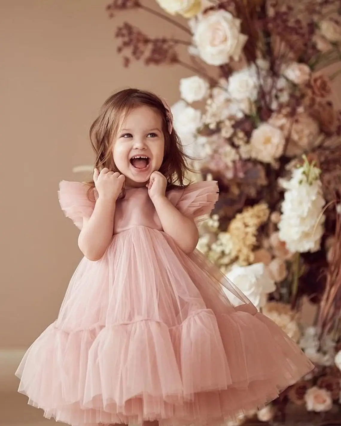 Front view of soft tulle and ruffle sleeves on blush pink toddler flower girl dress.